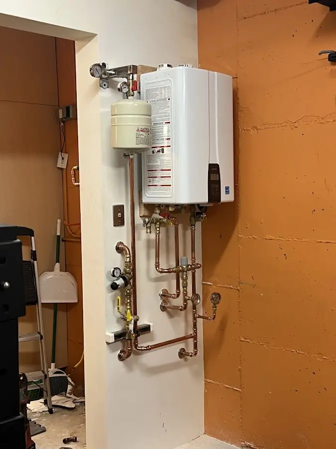 Plumbing technician inspecting water heater connections in Weldon Spring
